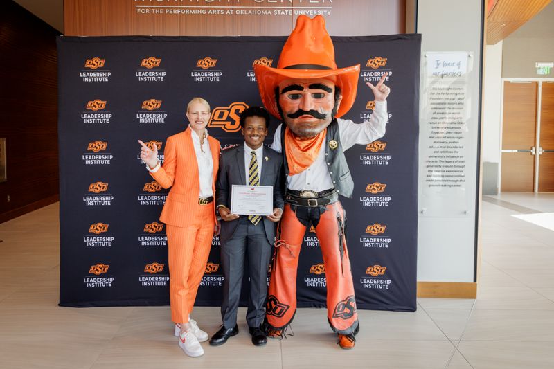 osu student receiving leadership award from university president and mascot