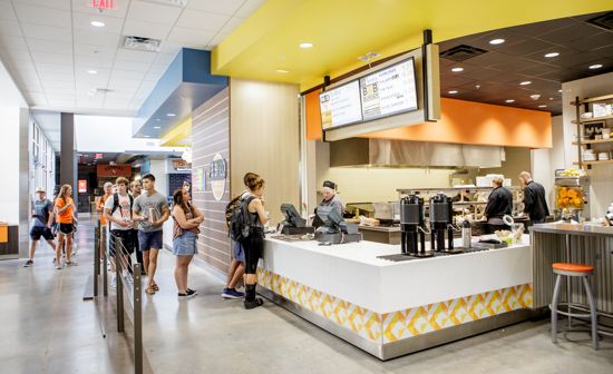 Students form a line to order food in the dining hall.