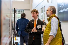 This student presents his findings to an attendee. 