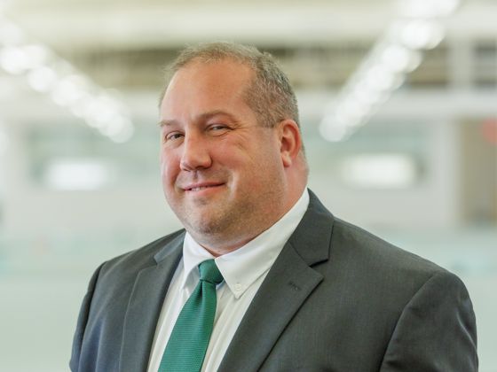 Man wearing a black suit with a green tie