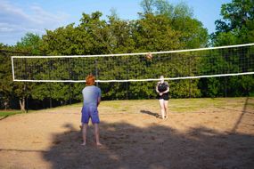 two students playing volleyball at Morrison Neighborhood court