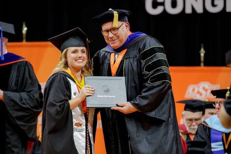 graduate receives diploma at commencement