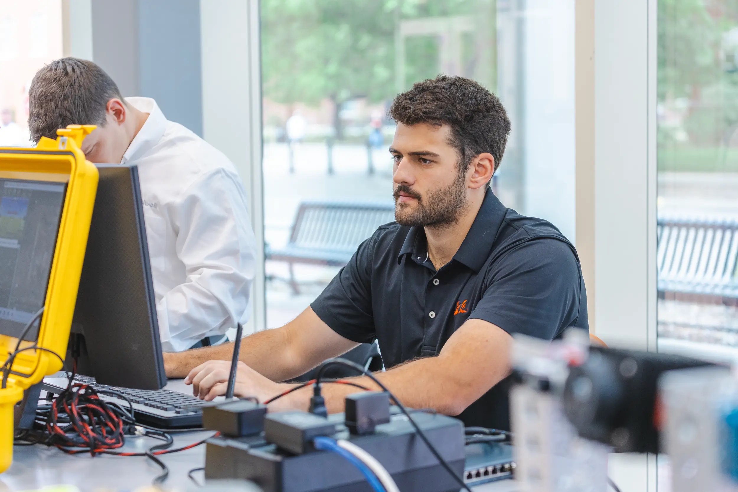 Male student works on desktop monitor in engineering lab.