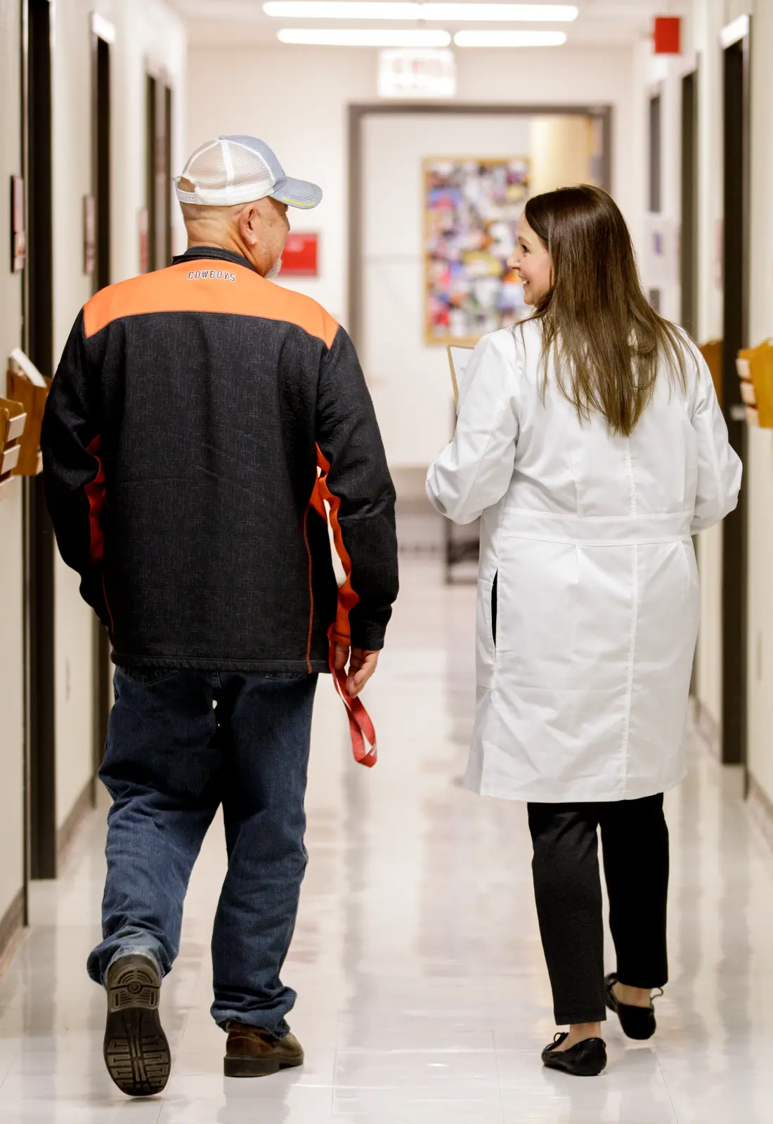 Doctor and client walking down hallway.