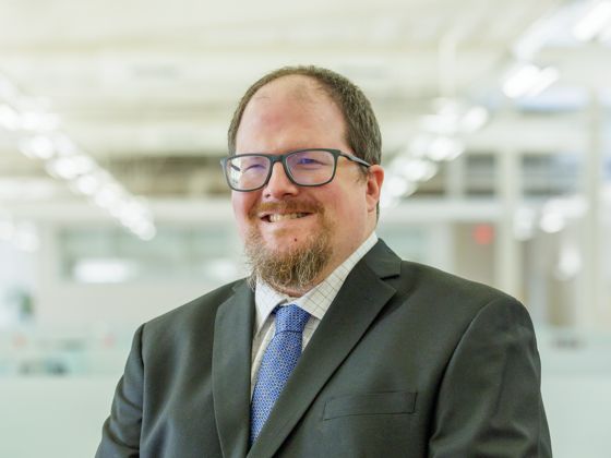 Man wearing a black suit with a blue tie