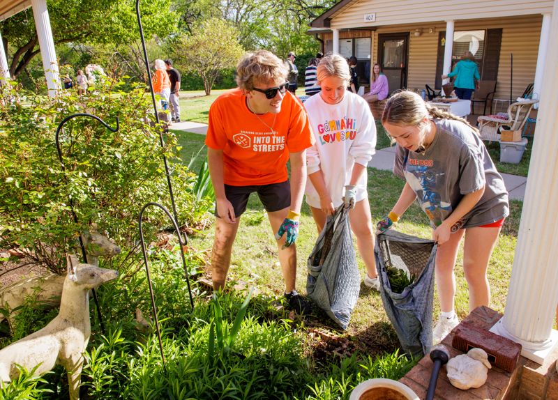 students volunteering to clean up yards in the community