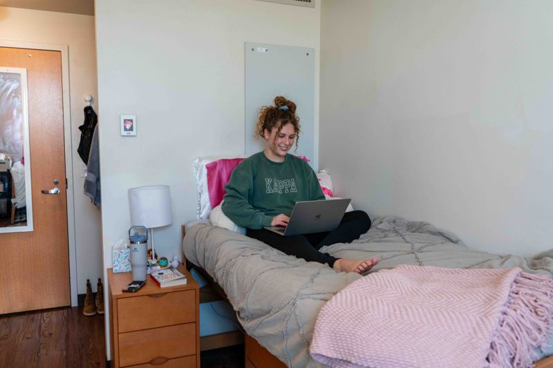 female sitting on her bed in the commons