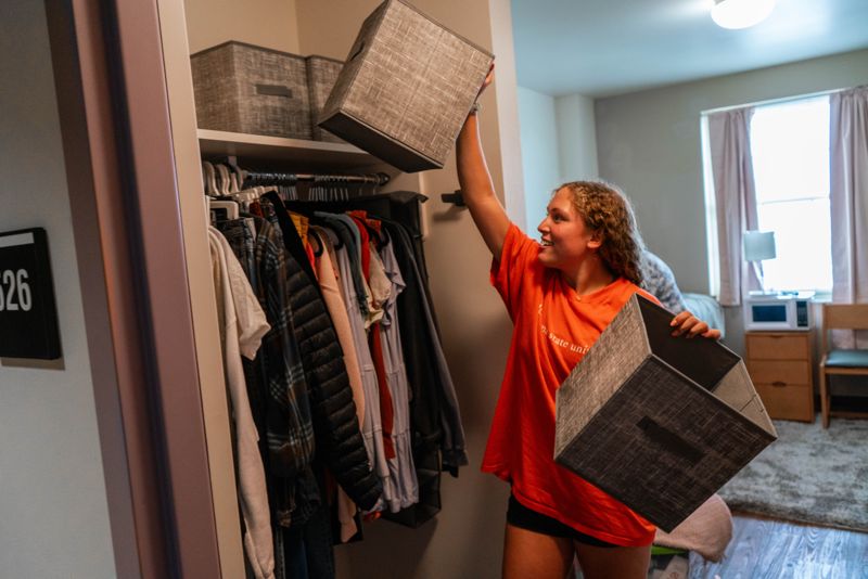 female organizing her closet in the commons