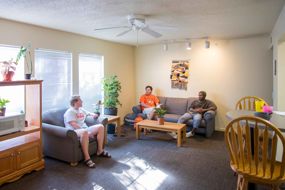 common area at bost hall three students sitting talking on couches